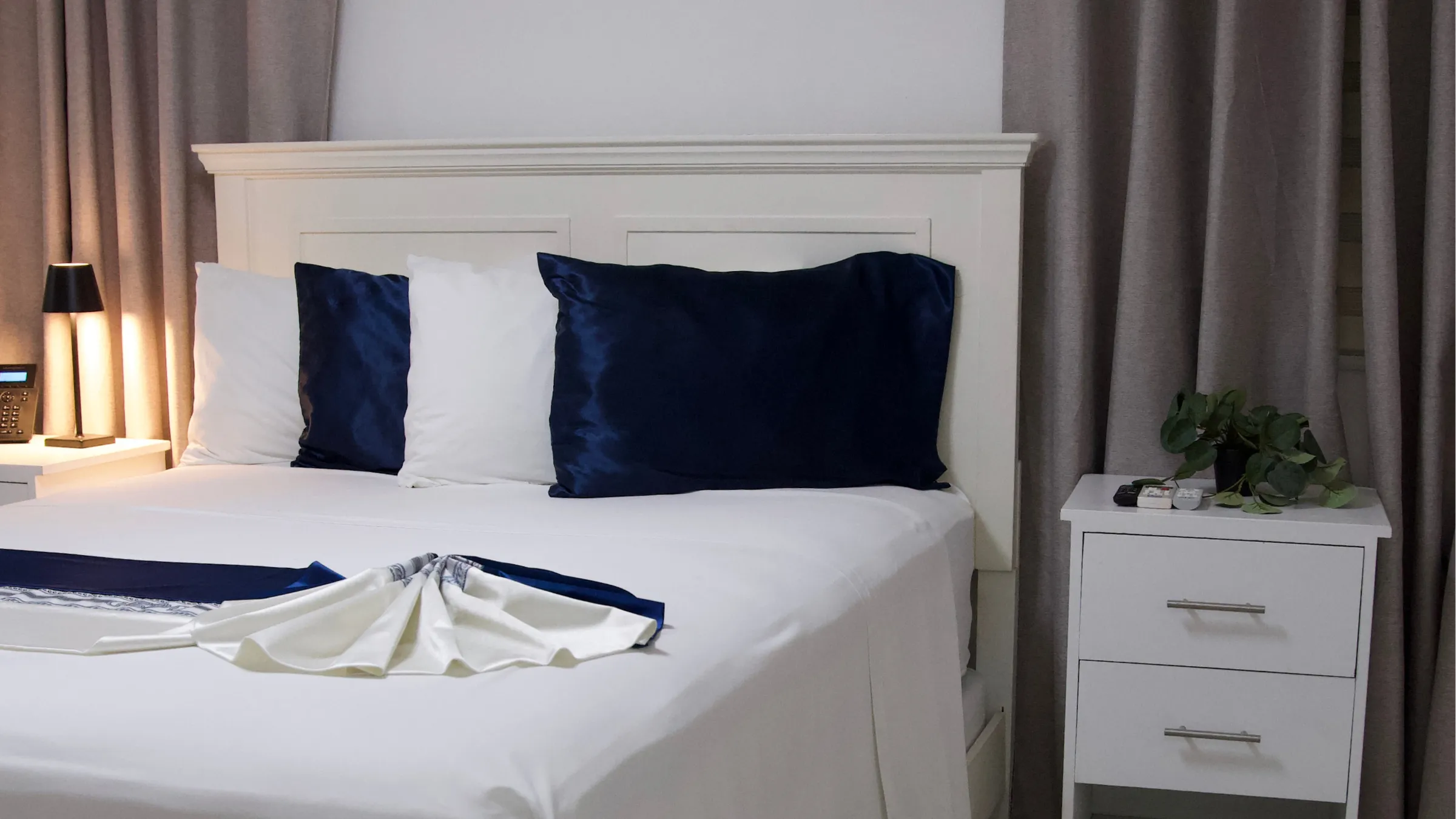 Habitación de estilo clásico con cama matrimonial y cojines azul marino